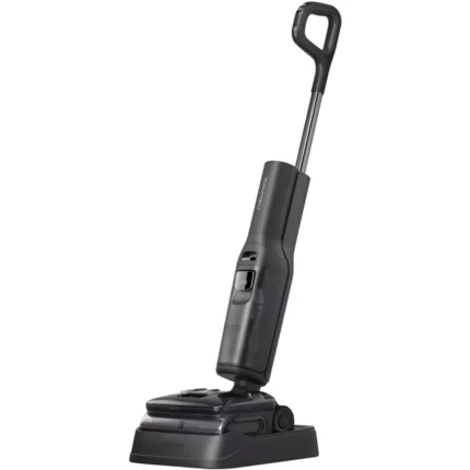 Cordless stick vacuum with a tall handle docked on its charging base.