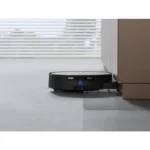 Robotic vacuum cleaner gliding under a cabinet in a modern home floor.