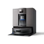 Robot vacuum with a tall, metallic docking/charging station branded Ecovacs, suggesting a self-emptying or charging unit attached to the cleaner.