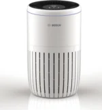 White cylindrical air purifier with a black vented top and a subtle Bosch logo on the side, standing on a reflective surface to the left.