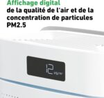 Close-up of a white air quality monitor showing a PM2.5 reading of 12 µg/m³ on a black display panel, with a green bold French title about air quality at the top.