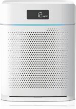 White compact air purifier with a perforated front panel, digital display showing 12 μg/m³ and a blue accent light.