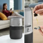Compact space heater with a built-in diffuser; left panel shows the unit on a table in a living room, right panel shows applying essential oil with a dropper into the diffuser cup.