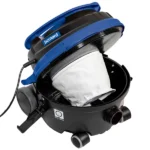 Portable shop vacuum with blue top and white bag inside a black canister, on wheels with a corded power connection (Bernard brand).