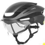 Grey Lumos bike helmet with integrated front and rear lights and a clear visor.