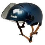 Blue Kask cycling helmet with a clear visor and brown adjustable straps, designed for head protection during riding.