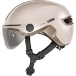 Beige ABUS racing bike helmet with clear visor and adjustable chin strap.