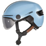 Light blue ABUS helmet with clear visor and chin strap, designed for winter sports safety.