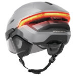White and gray full-face motorcycle helmet with an integrated orange LED tail light and adjustable chin strap.