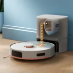 Autonomous robot vacuum docking beside a blue wall, transferring dirt into a smart trash can with a liftable bag.
