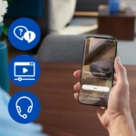 Person holds a phone showing the Philips HomeRun app login screen; three blue icons for Help chat, Video guide, and Support headset flank the left side.