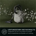 Vacuum cleaner with a shower of small white parts bursting from it, highlighting sustainability messaging about recycled plastic.