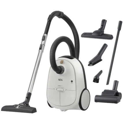 Canister vacuum cleaner with multiple attachments (floor head, hose, crevice tools) laid out around it for cleaning household floors and upholstery.