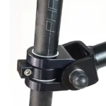 Close-up of a black adjustable clamp securing a vertical pole, with a side screw and knob