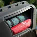 Mailbox open with camping gear inside: a rolled blue mat and a red MSR bag (Mountain Safety Research) visible