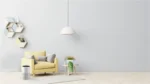 Bright living room featuring a pale yellow sofa, geometric hexagonal shelves on the left, a white pendant light, and potted plants against a light gray wall.