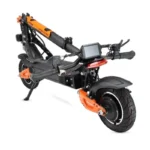 Folded electric scooter with orange highlights and a digital display mounted on the handlebar area for storage.
