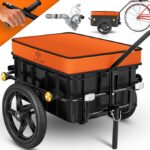 Bike cargo trailer with an orange padded lid and black plastic storage box, hitched to a bicycle frame with large wheels visible.