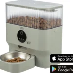Automatic pet feeder with a large transparent hopper filled with dry kibble and a front control panel; food bowl attached beneath. Overlaid App Store and Google Play badges appear in the corner.