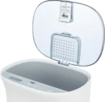 White compact countertop washing machine with its transparent hinged lid open, showing the inner tub and a touch control panel along the rim