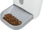 Automatic pet feeder bowl filled with dry brown kibble.
