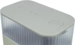 White compact electronic device with a rounded top and a ribbed body, featuring a prominent 'PRESS' button on the top panel and status icons.