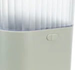Close-up of a white appliance with a ribbed translucent tank and a small on/off switch nearby (likely a power control).