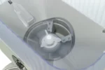 Close-up of a lab centrifuge rotor with white blades inside a transparent lid.