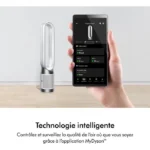 Dyson bladeless air purifier beside a hand-held phone displaying the MyDyson app with indoor air quality data.