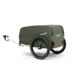 Olive-green Croozer bike trailer with two wheels and a closed cover, hitched for towing.