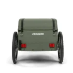 Green Croozer cargo trailer with two large wheels, viewed from the back, showing red reflectors and a zippered top, ready to hitch to a bike or stroller.