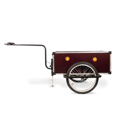 A vintage-style bicycle trailer with a dark red box, single rear wheel, and long tow bar attached at the front.
