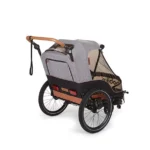 Two-wheeled bicycle cargo trailer with gray canopy and brown accents, designed to attach to a bike.
