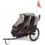 Two-wheeled child bike trailer with a mesh cover, gray canopy, and an orange safety flag on a white background.