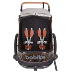Front view of a Bobike child bike trailer interior showing two orange harnesses and padded seats.