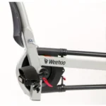 Close-up of a Weehoo bicycle trailer frame, showing the pedal crank, foot strap, and the logo on the grey tube.