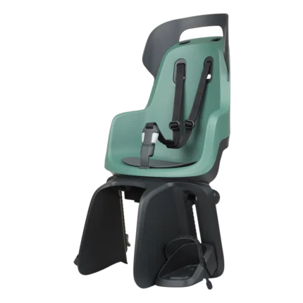 Green child bike seat with five‑point harness and foot straps mounted on a rear rack, ready for biking.
