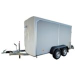 Enclosed dual-axle cargo trailer with a tow hitch for towing and dual wheels on each side