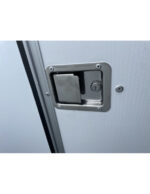 Close-up of a recessed door latch and lock on a light-gray metal exterior door, with visible screws around the frame.
