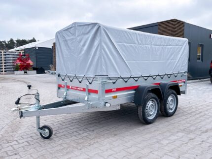 Tow trailer with a large gray tarp covering a cargo area, mounted on two axles with gray metal frame and red Temared branding, parked on a paved lot.